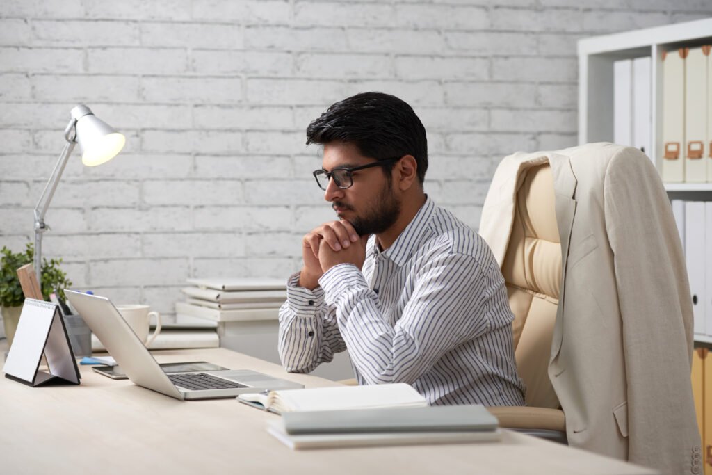 A person checking email with mindfulness is showing karma yoga for working professional.