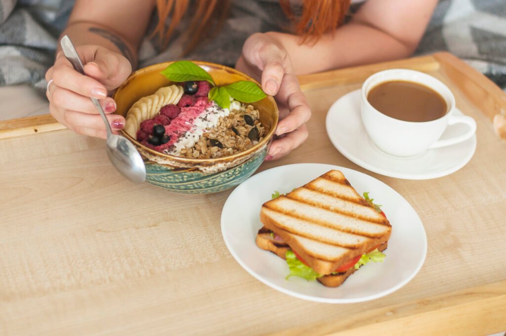 Sattvic Breakfast bowl with granola fruits and herbal tea on wooden tray